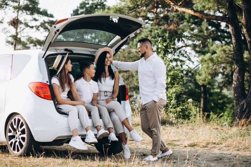 Parents with their children on car in the field